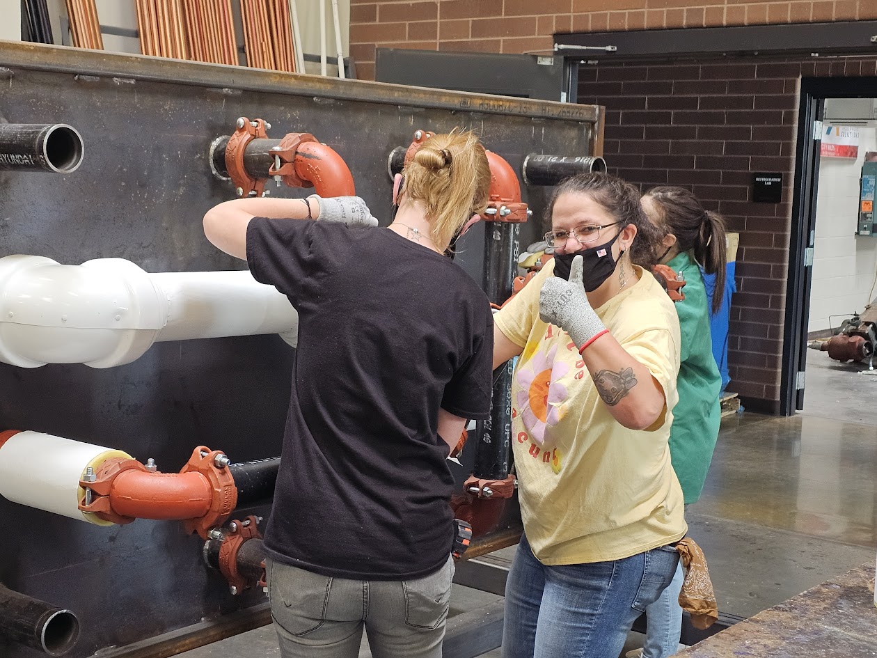 A man and a woman looking at a man in a mask.
