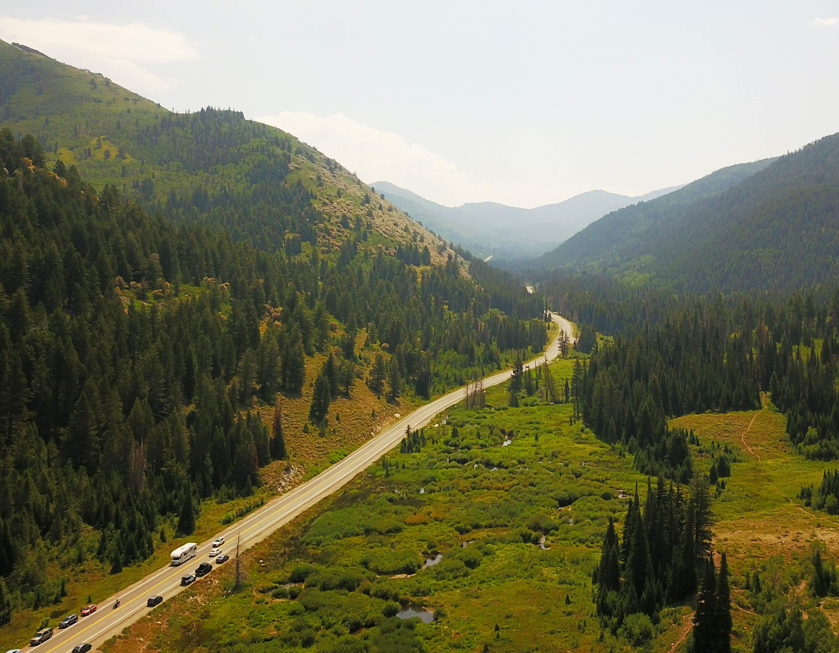 A road with trees and mountains.