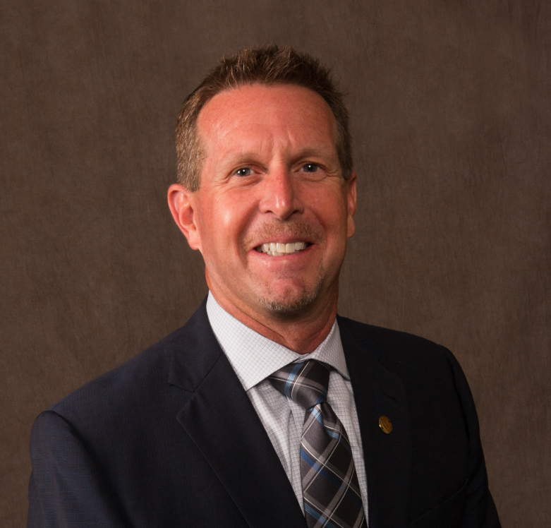 A man in a suit smiling.