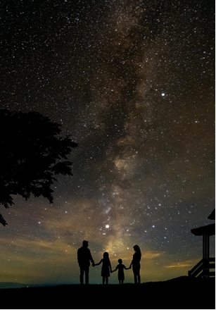 A family standing in front of a starry sky.