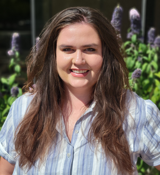 A person with long hair smiling.