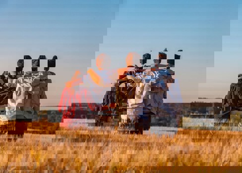 A group of people hugging in a field.