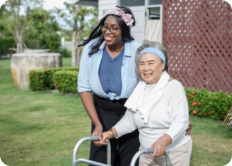 A woman and a man on a wheelchair in a yard.