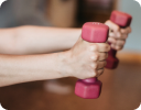 A close-up of a hand holding a pink and white object.