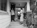 A couple of women standing outside a house.