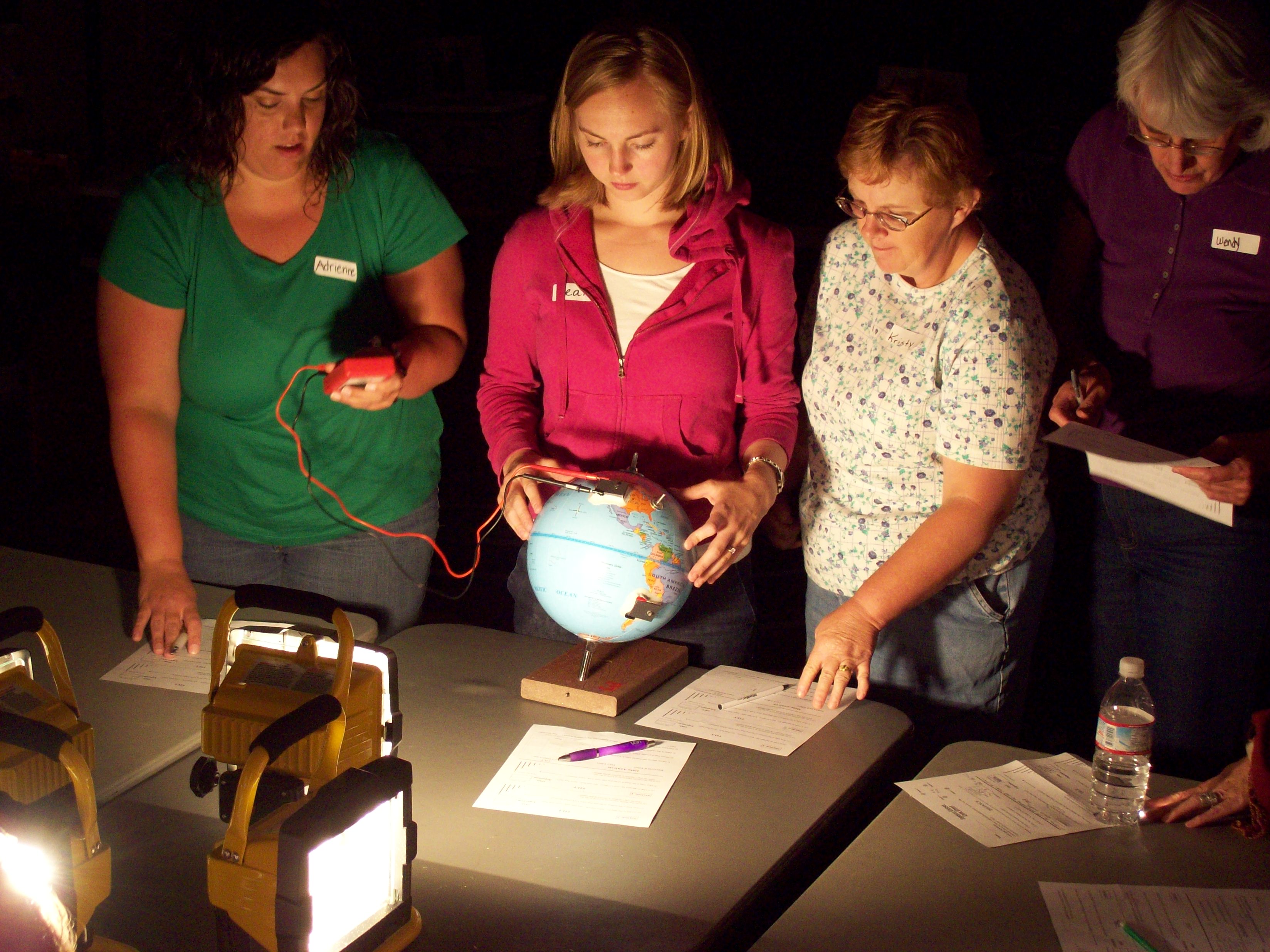A group of women looking at a globe.
