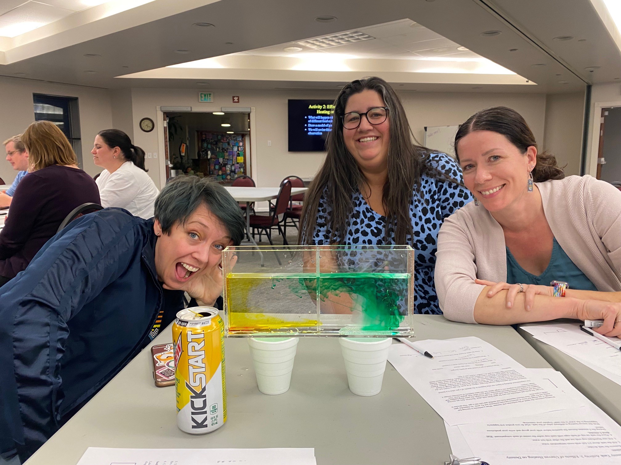 Gabriella Vidus et al. sitting at a table with a can of soda.