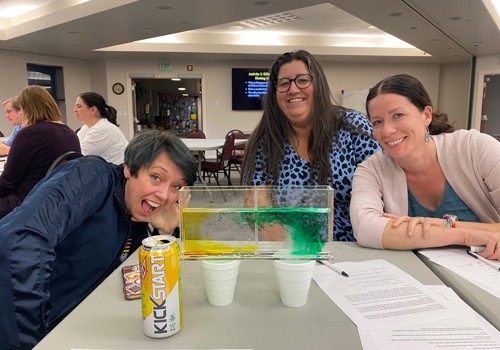 Gabriella Vidus et al. sitting at a table with a can of soda.