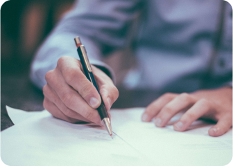 A person writing on a piece of paper.