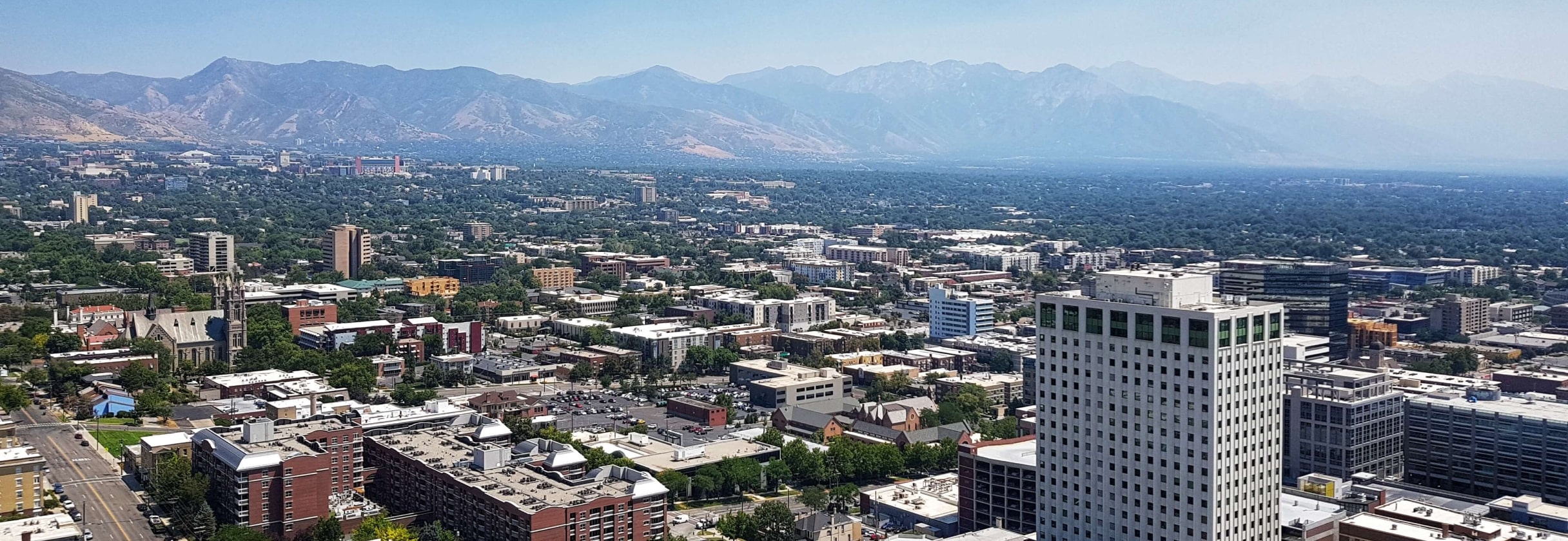 A city with many buildings and a body of water in the background.