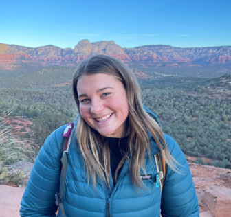 A woman smiling with a canyon in the background.