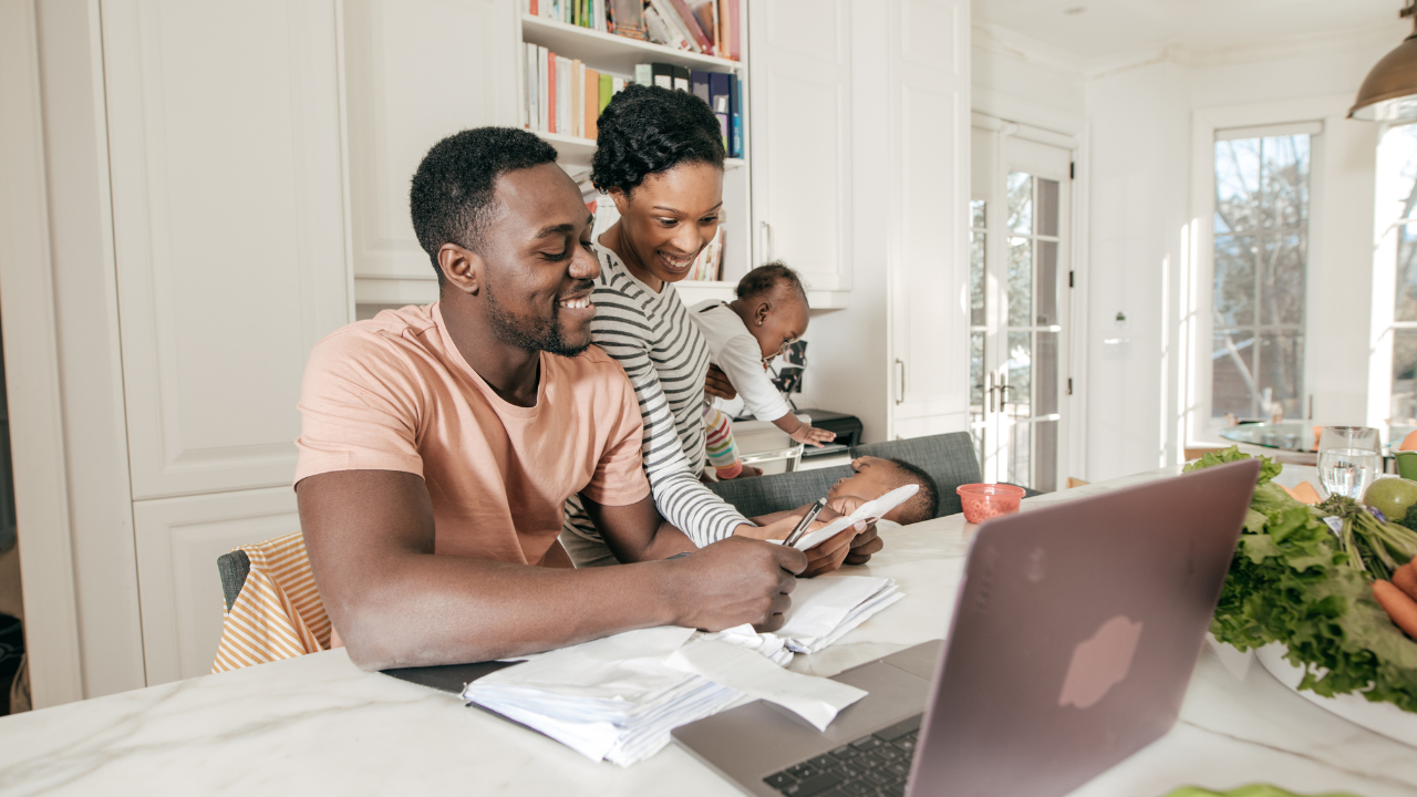 A group of people looking at a laptop.