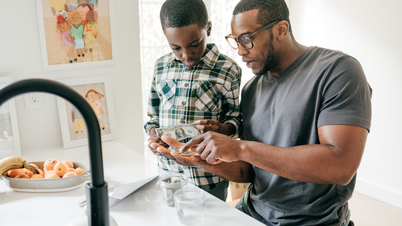 A man and a boy looking at a cell phone.