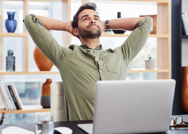 A man sitting at a desk with his head on his hand.