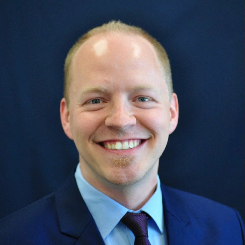 A man in a suit smiling.
