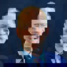 A man in a suit smiling.