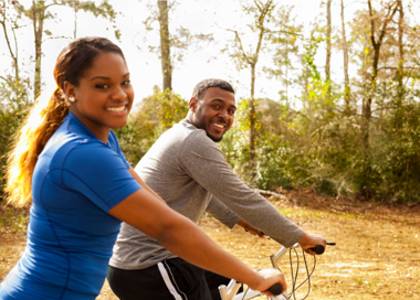 A man and a woman riding a bicycle.