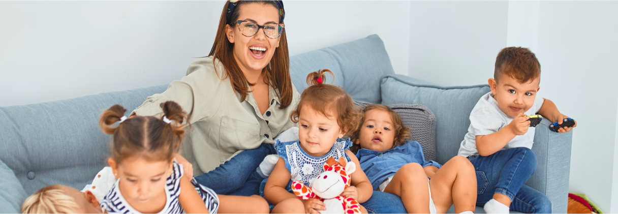 A person and several children sitting on a couch.