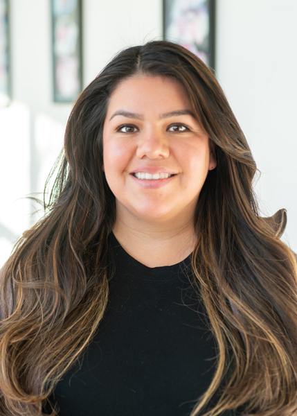 A woman with long hair smiling.