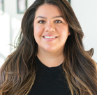 A woman with long hair smiling.