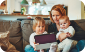 A person and two children sitting on a couch looking at a laptop.