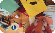 A child painting on a yellow paper.