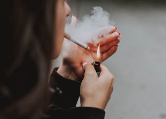 A woman lighting a cigarette.