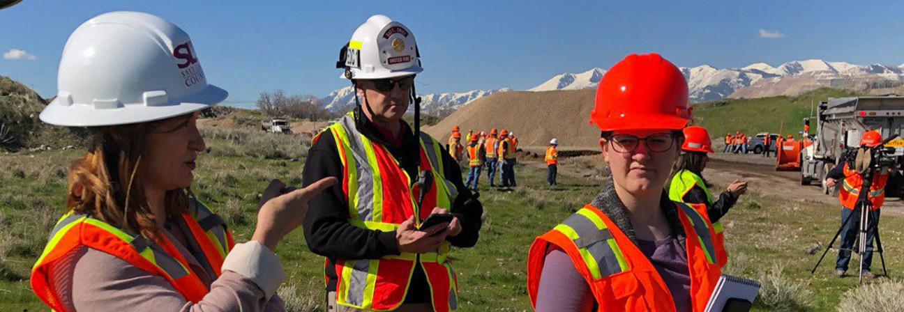 Mayor Wilson and two other people wearing hard hats at a work site outdoors.