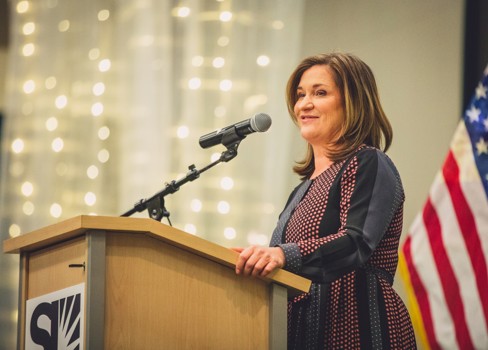 Jenny Wilson standing at a podium.
