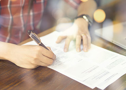 A person writing on a piece of paper.
