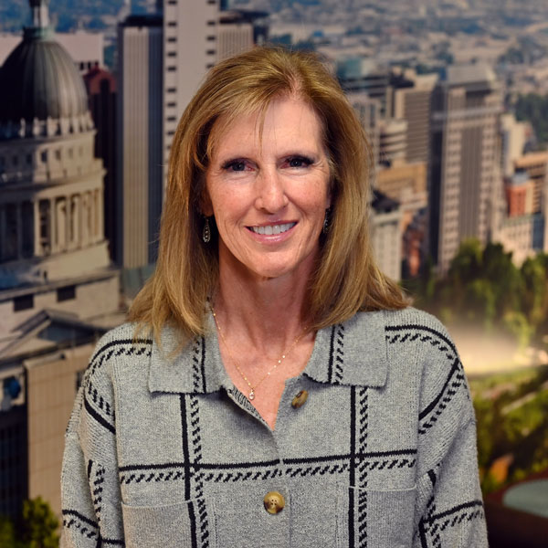 A woman smiling with a city in the background.