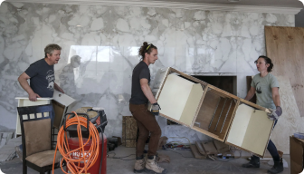A group of people working on a wood project.