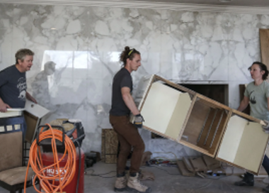 A group of people working on a wood project.