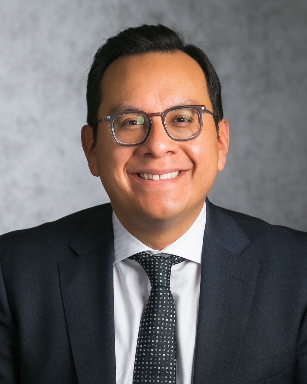 A man wearing glasses and a suit.