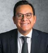 A man wearing glasses and a suit.