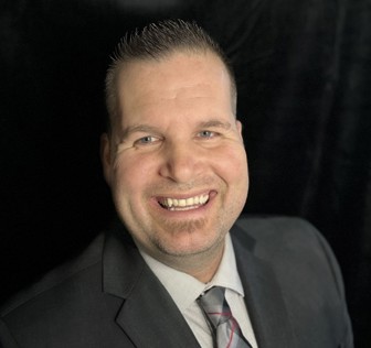 A man in a suit smiling.