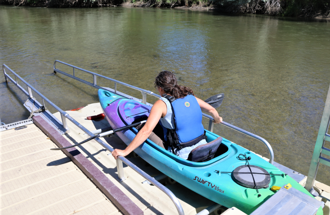 A girl in a kayak on a dock.