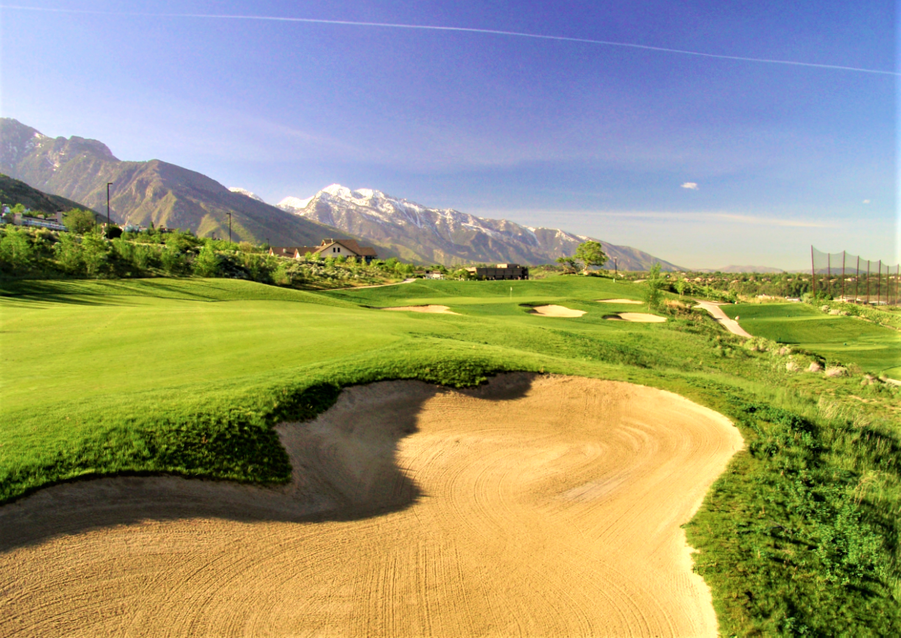 A dirt road leading to a mountain range.