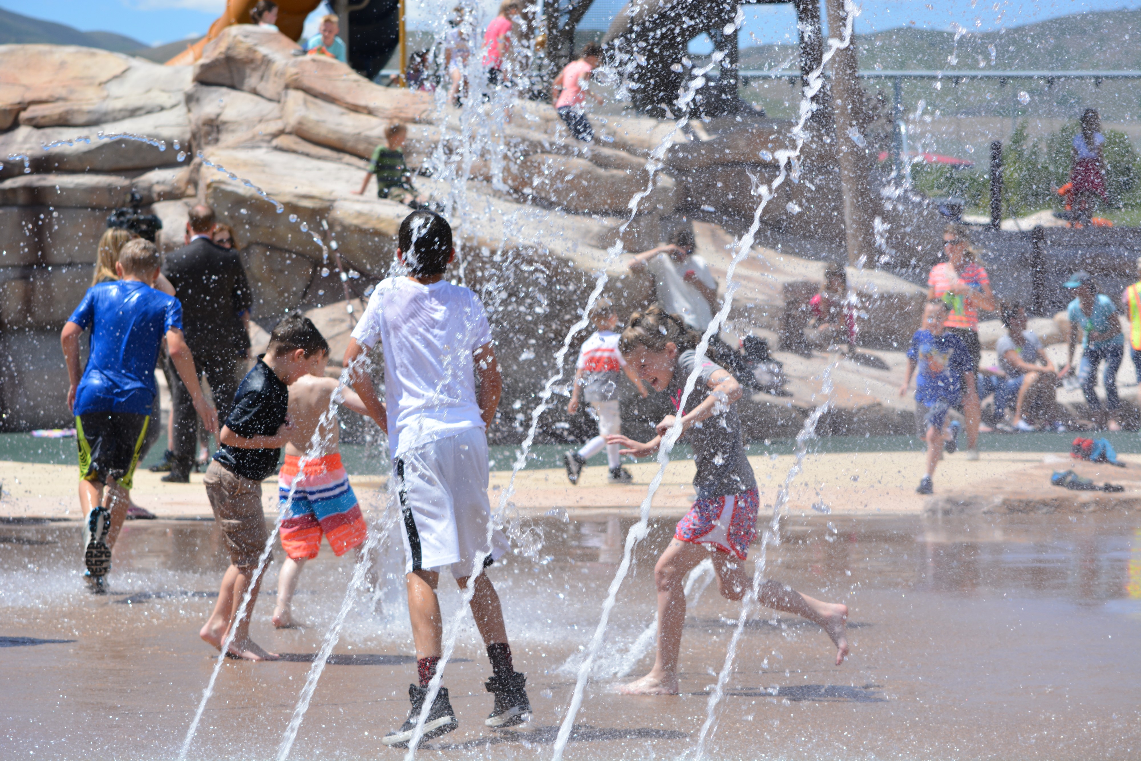 A group of people playing in a water fountain.